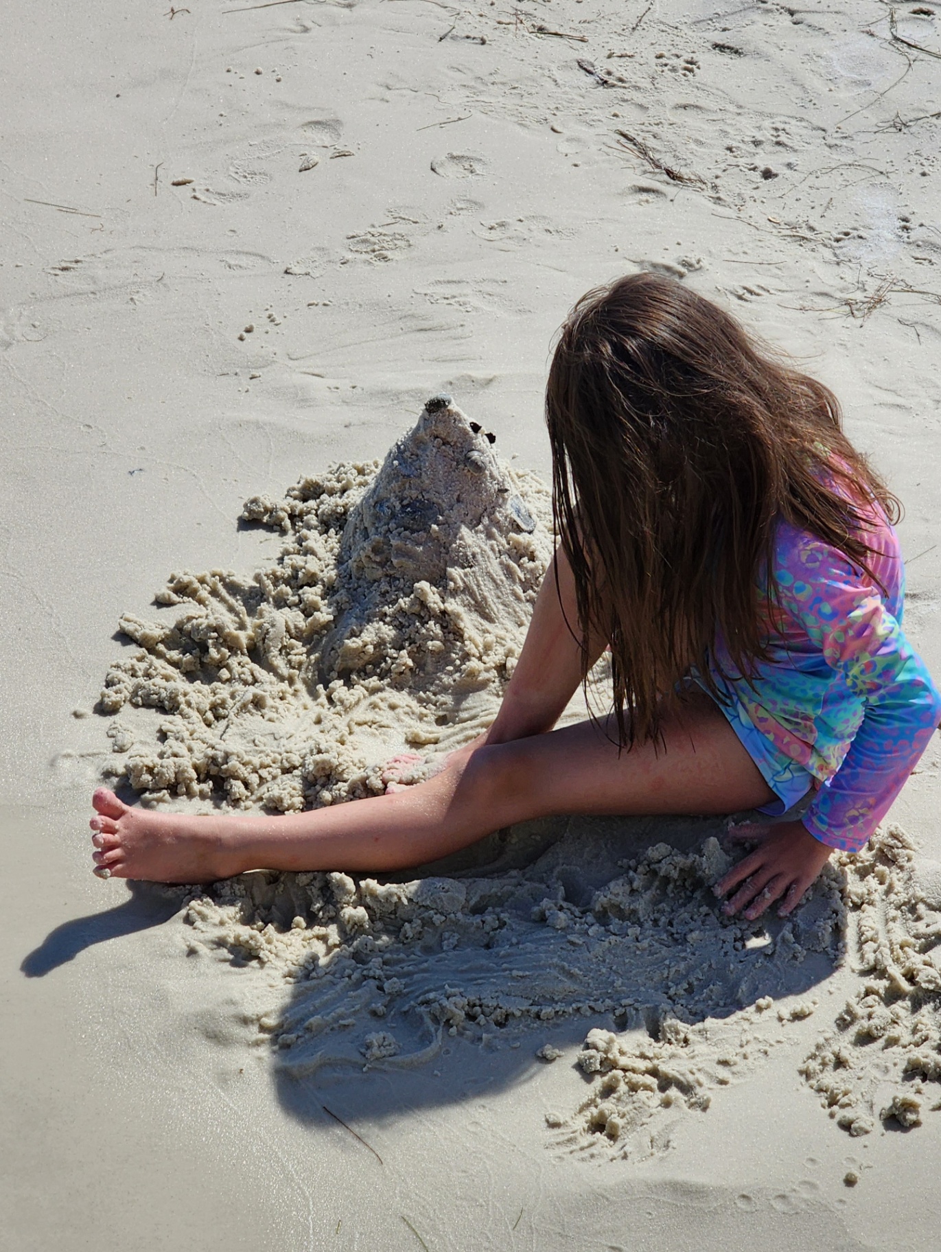 A young guest building a sandcastle on the white-sand beach