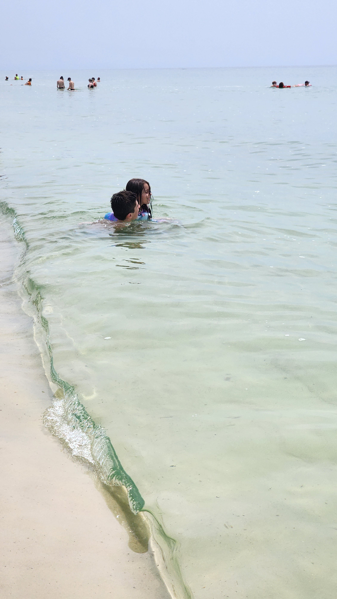 Kids swimming together in the calm, clear Gulf shallows