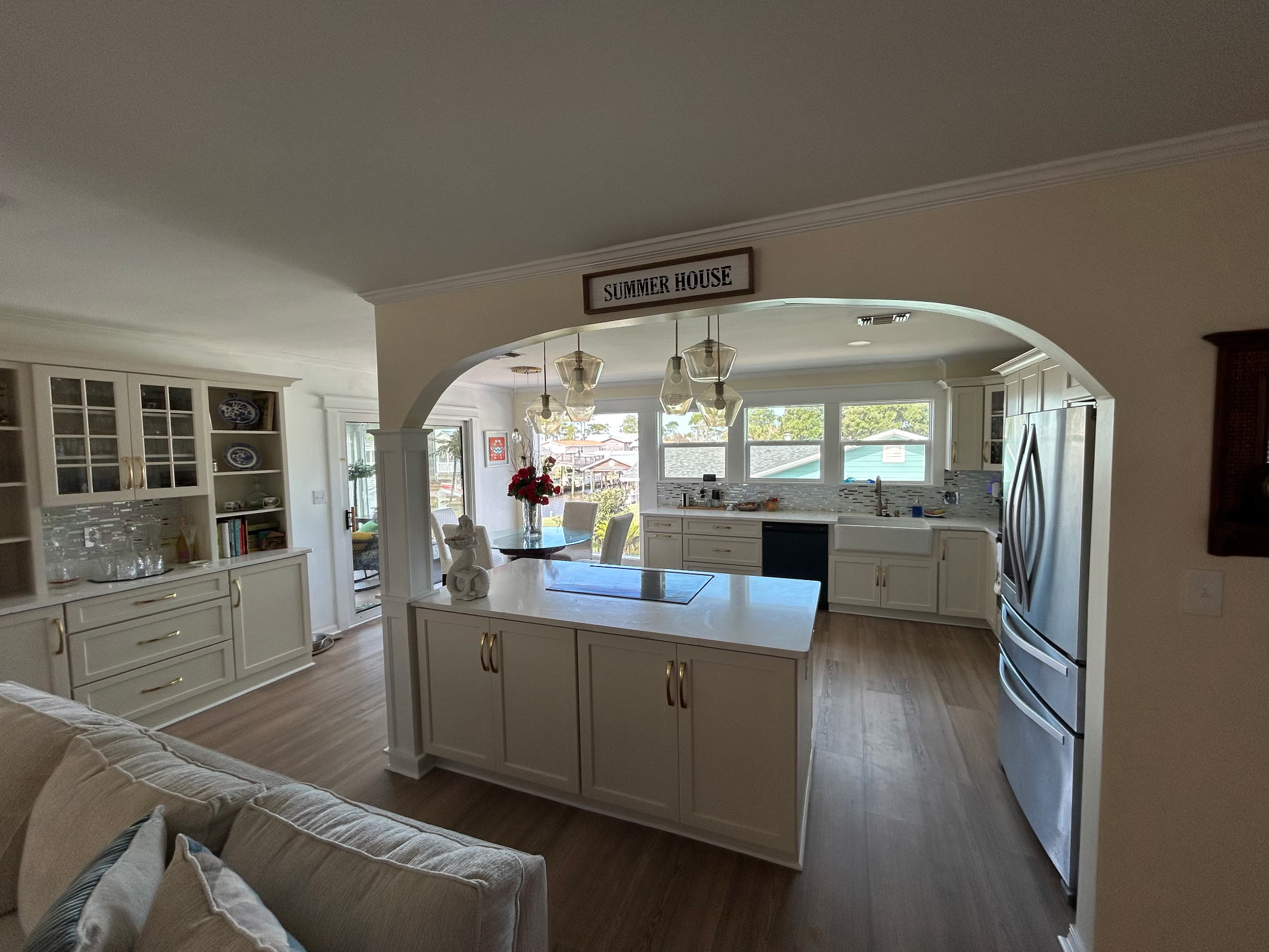 Open living area with a Summer House sign above the arched kitchen entry, looking through to the dining table